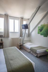 a hotel room with two beds and a staircase at Hôtel Le Rohan Charme et Caractère in Pontivy