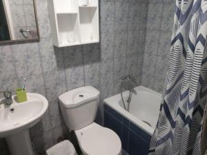 a bathroom with a toilet and a sink and a tub at Hostal D&N servicios 