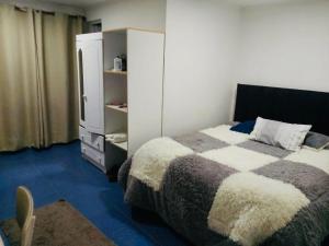 a bedroom with a bed and a cabinet and a television at Hostal D&N servicios 