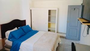 a bedroom with a bed and a blue door at Hostal D&N servicios 