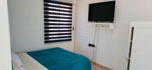 a bedroom with a bed and a flat screen tv at Hostal D&N servicios 