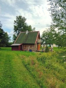 eine alte Scheune mit grünem Dach auf einem Feld in der Unterkunft Pirgu forell in Rapla