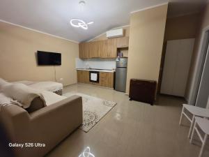 a living room with a couch and a kitchen at Vila HOXHA in Hamallë