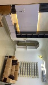 a room with a ceiling with a bed and a staircase at The Nest Homes in Abuja