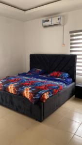 a bed with a blue comforter in a room at The Nest Homes in Abuja