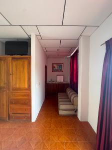 a hallway with a room with a couch and a tv at Hotel Barbasquillo in Manta