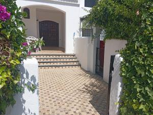 a walkway leading to a door in a house at Villa pieds dans l'eau Cabo in Cabo Negro