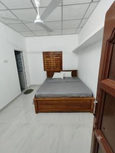 a bedroom with a bed in a white room at Amma's Homestay in Jaffna