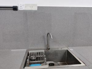 a kitchen sink with a dish strainer in it at Amma's Homestay in Jaffna