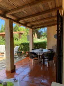 a patio with a table and chairs under a wooden pergola at Botrus Divin Casa in Brindisi