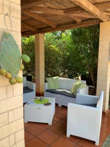 a patio with white wicker chairs and a table at Botrus Divin Casa in Brindisi