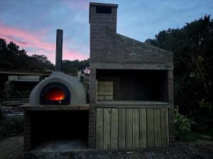 a pizza oven with a fire inside of it at La pinta roja in Punta Del Diablo