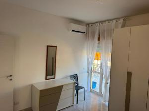 a white room with a dresser and a mirror at DE ROSA'S home 4 in Praia a Mare