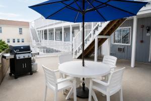 a table with a blue umbrella on a patio at Neptune Motel Maine in Old Orchard Beach