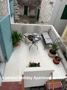 a balcony with a table and chairs on a patio at Murter-Sun Stone House in Murter +2 photos