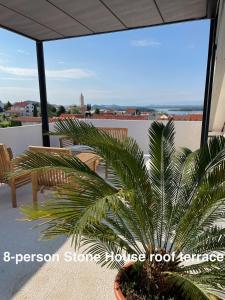 a palm tree in a pot on a balcony at Murter-Sun Stone House in Murter