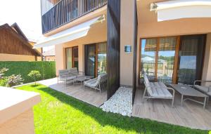 a house with a patio with chairs and a table at Apartamente Nefeli in Curtea de Argeş
