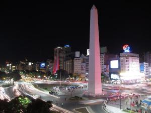 a large obelisk in the middle of a city at night at APART CyJ OBELISCO in Buenos Aires
