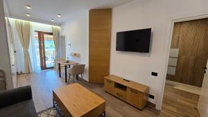 a living room with a flat screen tv on a wall at Apartamente Nefeli in Curtea de Argeş