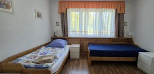 a bedroom with two beds and a window at Ferienwohnung Helena in Markkleeberg