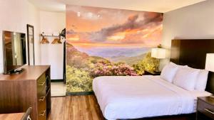 a hotel room with a bed and a painting on the wall at Clarion Pointe in Charlotte