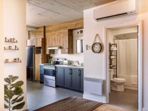a kitchen with blue cabinets and a clock on the wall at Lofts Orizon in Rimouski +59 photos