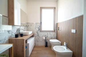 a bathroom with a sink and a toilet and a window at Civico 91 Guest House in Silì +32 photos