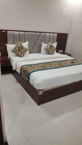 a bed with two pillows on it in a room at Hotel Grand Taj Pride in Tājganj