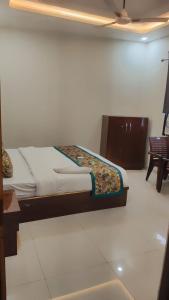 a bedroom with a bed and a couch and a chair at Hotel Grand Taj Pride in Tājganj