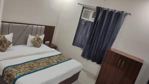 a bedroom with a bed and a window at Hotel Grand Taj Pride in Tājganj