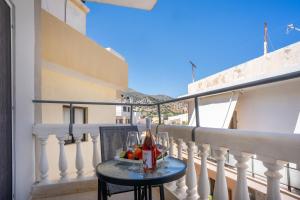 a table with wine glasses and fruit on a balcony at Malia Boutique Studios in Malia