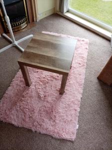 a wooden coffee table on a pink rug in a room at Lucy retreat in Great Driffield