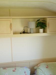 a shelf above a bed with a lamp and a pillow at Lucy retreat in Great Driffield