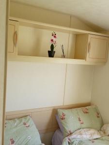 a room with two pillows and a shelf with a plant at Lucy retreat in Great Driffield