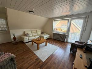 a living room with a couch and a table at Lenyanca Apartment in Salzbergen +2 photos