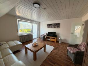 a living room with a couch and a table at Lenyanca Apartment in Salzbergen