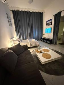 a living room with a couch and a bed at Single room Jimi in Al Ain