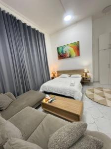a living room with a bed and a couch at Single room Jimi in Al Ain