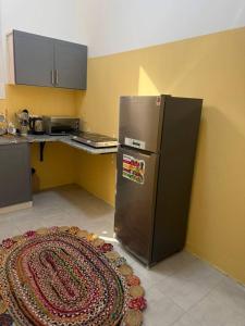 a kitchen with a refrigerator and a kitchen rug at Single room Jimi in Al Ain