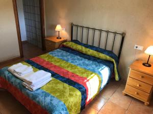 a bedroom with a bed with a colorful blanket at Casa Rural La Granja in Letur