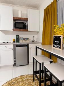 a kitchen with white cabinets and a table and chairs at Your Blooming Getaway in Nassau