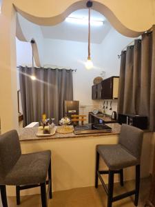 a kitchen with a counter with two chairs and a table at Cozy studio AlJimi in Al Ain +13 photos