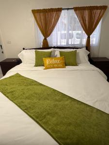 a white bed with a yellow pillow on it at Your Blooming Getaway in Nassau +8 photos