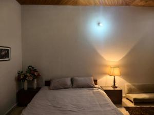 a bedroom with a bed and a lamp and a couch at Naqvi House in Murree