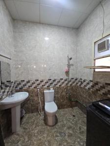 a bathroom with a toilet and a sink at Cozy studio AlJimi in Al Ain