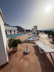 a group of lounge chairs on a building with a pool at Couples Only, beautiful 1 Bedroom Apartment in Victoria Building in Mojácar