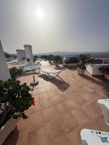 a patio with lounge chairs and plants on a building at Couples Only, beautiful 1 Bedroom Apartment in Victoria Building in Mojácar
