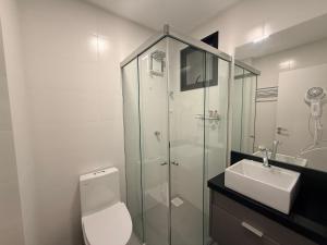 a bathroom with a shower and a toilet and a sink at Studio with pool, pool table, gym and sauna in Itapema +21 photos