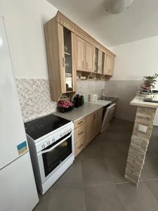 a kitchen with wooden cabinets and a white stove top oven at Apartment Petar in Kotor +4 photos