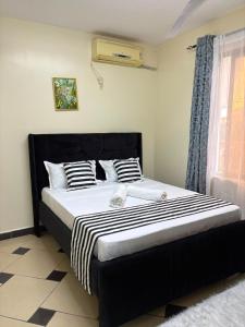 a large bed in a room with a window at Terry's 2br sunsweet resort shanzu,mombasa in Mombasa